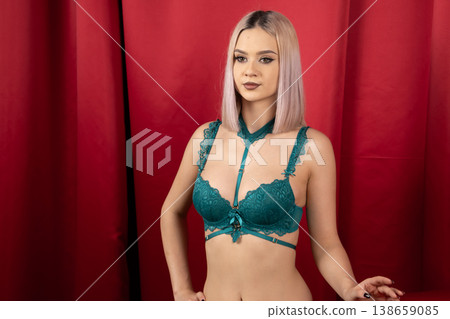 Young woman in green lingerie looking down in studio Young woman in green lingerie looking down in studio 138659085