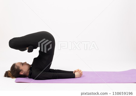 Woman doing advanced yoga inversion pose on a fitness mat Woman doing advanced yoga inversion pose on a fitness mat 138659196
