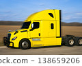 Detailed side profile of a yellow truck cabin on a spring field 138659206