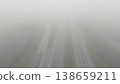 Aerial view of a wide straight highway disappearing into thick fog 138659211