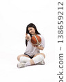 Young woman sitting on floor and holding a ball 138659212