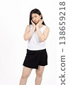 Woman posing with hands on chin and looking away in studio 138659218