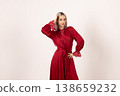 Beautiful woman in red dress posing with hand on head 138659232