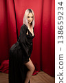 Pretty woman in black robe posing sideways in studio 138659234