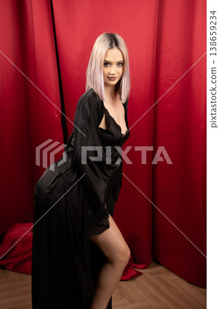 Pretty woman in black robe posing sideways in studio Pretty woman in black robe posing sideways in studio 138659234
