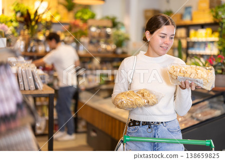 Store visitor, girl in sales area choosing pasta Store visitor, girl in sales area choosing pasta 138659825