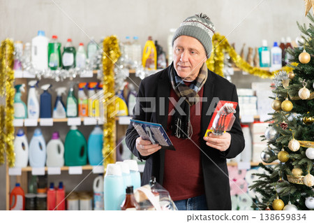 Senior man select and studies label razor on New Year Eve Senior man select and studies label razor on New Year Eve 138659834