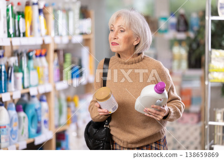 woman chooses cleaning products and rinse aid in the store woman chooses cleaning products and rinse aid in the store 138659869