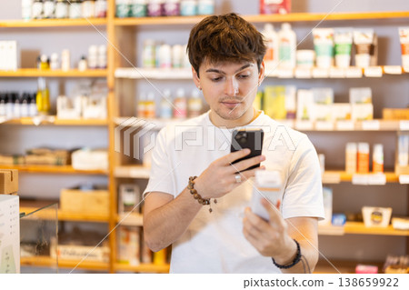 Guy get acquainted with dietary supplement, scan QR code, take reading label using phone camera Guy get acquainted with dietary supplement, scan QR code, take reading label using phone camera 138659922