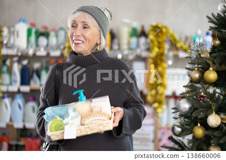 Elderly woman buyer chooses cosmetics gift set for christmas 138660006