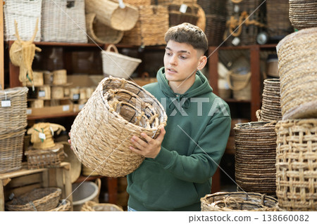 Male shopper in furniture center chooses new wicker laundry basket Male shopper in furniture center chooses new wicker laundry basket 138660082