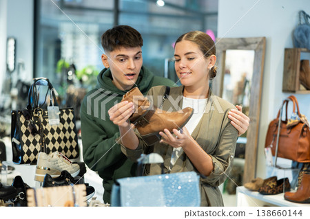 Young couple shopping for comfortable fall footwear in shoe store 138660144