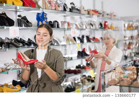 Young woman chooses stilettos in shoe store Young woman chooses stilettos in shoe store 138660177