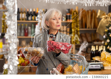 While shopping on eve of New Year holidays, elderly lady buys sweets for festive party While shopping on eve of New Year holidays, elderly lady buys sweets for festive party 138660221