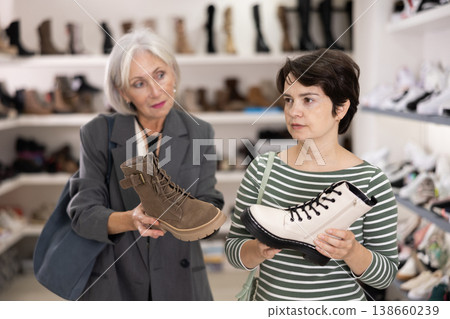 Two women are shopping in shoe store Two women are shopping in shoe store 138660239