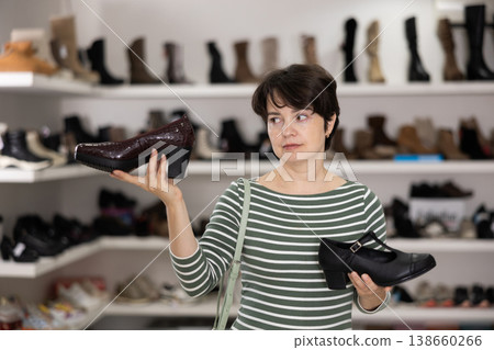 Adult woman chooses classic shoes in shoe store Adult woman chooses classic shoes in shoe store 138660266
