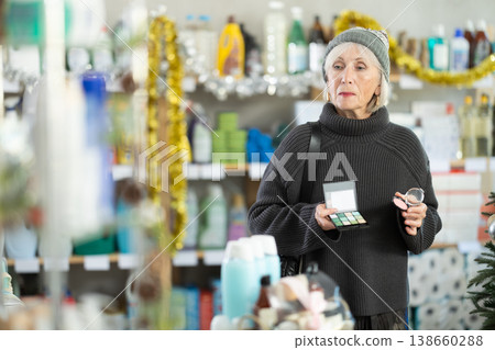 Elderly woman chooses cosmetics in decorated household chemicals store Elderly woman chooses cosmetics in decorated household chemicals store 138660288