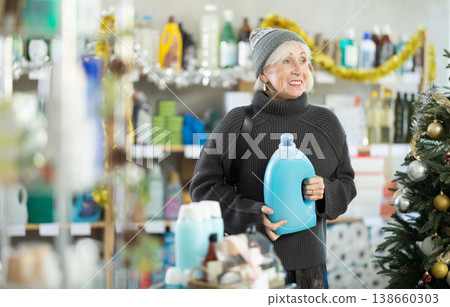 Elderly woman chooses detergent in supermarket before Christmas Elderly woman chooses detergent in supermarket before Christmas 138660303