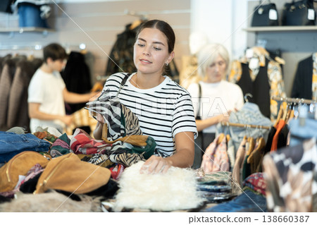 She browses through racks of pre-loved clothing She browses through racks of pre-loved clothing 138660387