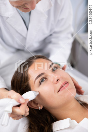 Young woman having face vacuum cleaning procedure 138660445
