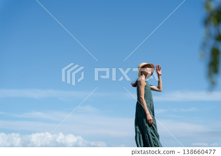 一位穿著洋裝的女子站在藍天下 一位穿著洋裝的女子站在藍天下 138660477