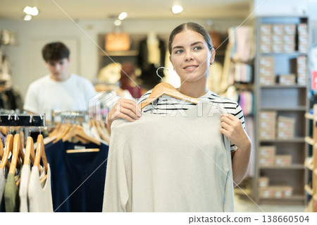 Young girl choosing convenient jumper in clothing store Young girl choosing convenient jumper in clothing store 138660504