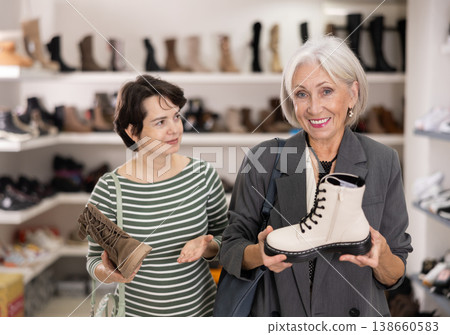 Adult and elderly women choosing boots in store Adult and elderly women choosing boots in store 138660583