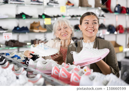 Elderly woman and young woman choosing sneakers in shoe store 138660599