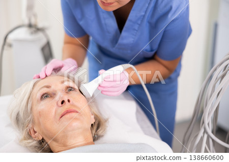 Old woman having face laser therapy procedure 138660600