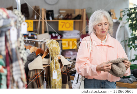 Elderly woman choosing hat in clothing store 138660603