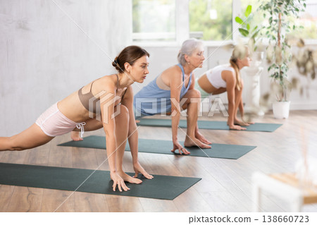 Young woman doing pilates in group in studio Young woman doing pilates in group in studio 138660723