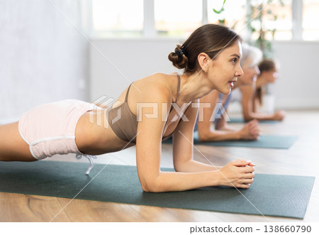 Women of different generations yoga showing plank pose in wellness center Women of different generations yoga showing plank pose in wellness center 138660790