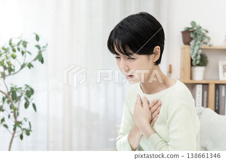 一名女子摀住胸口，突然感到不適；胸痛，壓力過大。 138661346