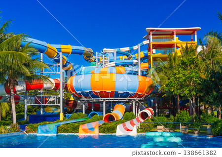 water park with slides and pipes for active extreme recreation at resort in summer. Big colorful aquapark with a pool water park with slides and pipes for active extreme recreation at resort in summer. Big colorful aquapark with a pool 138661382