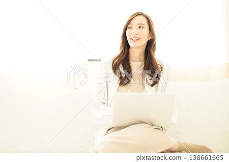 A woman using a laptop on her lap. A woman using a laptop on her lap. 138661665