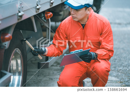 Checking tire pressure in trucks using an inspection hammer Checking tire pressure in trucks using an inspection hammer 138661694