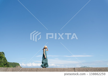 Woman walking along the beach in summer Woman walking along the beach in summer 138662250