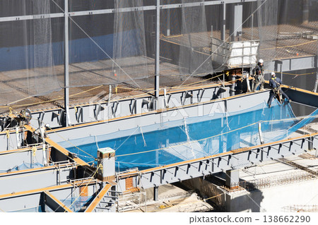 Workers performing high-altitude work and installing safety nets at a steel frame construction site. New logistics facility construction project 6. Workers performing high-altitude work and installing safety nets at a steel frame construction site. New logistics facility construction project 6. 138662290