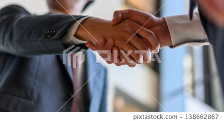 A handshake between two businessmen in suits A handshake between two businessmen in suits 138662867