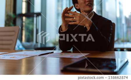 A man explains things using gestures in a meeting. 138662874
