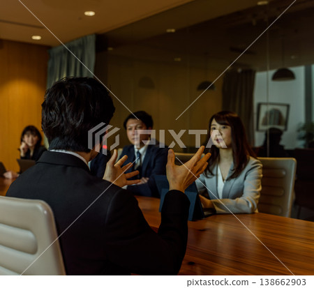 一名男子在會議上發言,一名女子在旁邊聆聽。 一名男子在會議上發言,一名女子在旁邊聆聽。 138662903