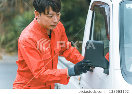 A mini-truck's side mirror and a car mechanic 138663102