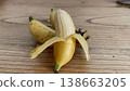 Peeled ladyfinger banana on wooden table close up. A cluster of small ripe ladyfinger bananas on a rustic wooden background with one banana partially peeled and standing upright in the foreground. 138663205