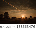 Spectators Silhouetted Against Sunset Watching Rocket Lift Off into the Sky 138663476