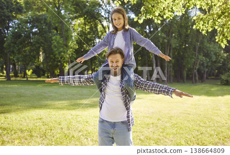 Happy smiling child boy sitting on fathers shoulders enjoying beautiful nature walking together. Happy smiling child boy sitting on fathers shoulders enjoying beautiful nature walking together. 138664809