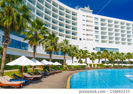 luxury hotel with a swimming pool and palm trees in summer resort luxury hotel with a swimming pool and palm trees in summer resort 138665255