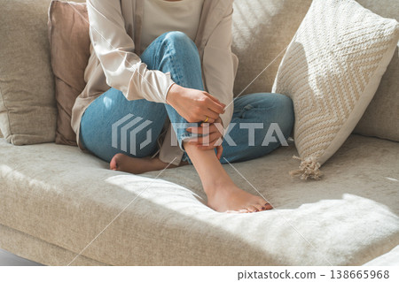 一位時尚的亞洲家庭主婦在客廳沙發上放鬆地躺著,露出她的雙腳。 一位時尚的亞洲家庭主婦在客廳沙發上放鬆地躺著,露出她的雙腳。 138665968