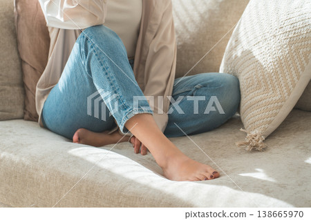 一位時尚的亞洲家庭主婦在客廳沙發上放鬆地躺著,露出她的雙腳。 一位時尚的亞洲家庭主婦在客廳沙發上放鬆地躺著,露出她的雙腳。 138665970