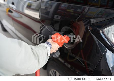 A scene of someone refueling at a gas station. 138666323