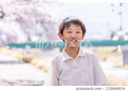 一個笑容燦爛的男孩在春意盎然的公園裡玩耍。 一個笑容燦爛的男孩在春意盎然的公園裡玩耍。 138666654